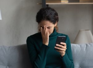 woman stressed out holding her phone