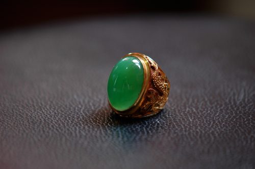 Chrysoprase and gold ring on black background
