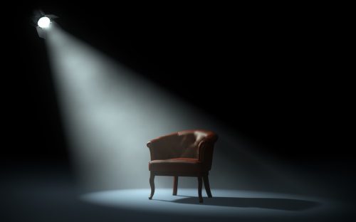 chair on stage under spotlight