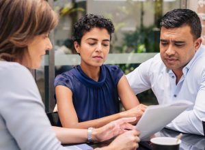 A couple speaking with a financial planner with serious looks on their faces