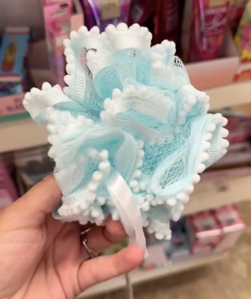 A shopper holds a loofah while shopping for the best Mother's Day gifts in Dollar Tree.