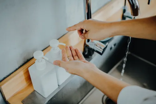 Cropped shot of a man dispensing soap before washing his hands in the sink