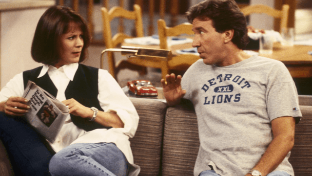 Actors Patricia Richardson and Tim Allen sitting on a couch in an episode of Home Improvement.