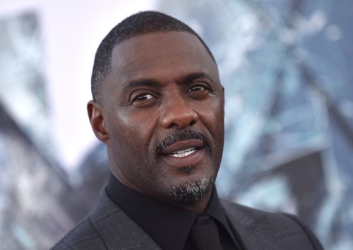 Portrait of Idris Elba with a goatee wearing a black suit