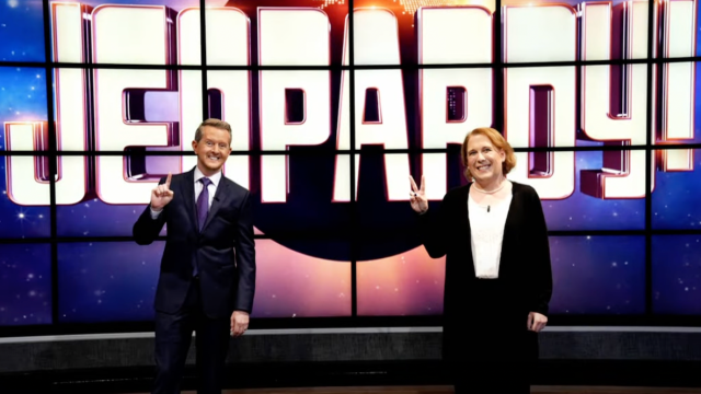 Ken Jennings and Amy Schneider posing in front of a Jeopardy board
