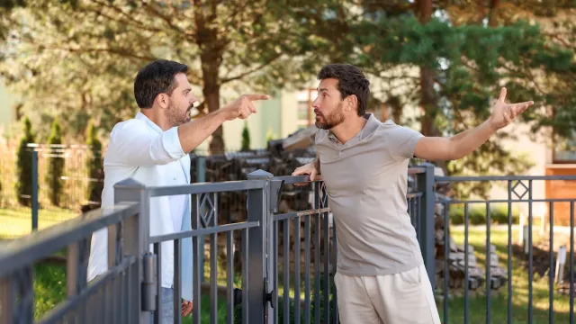 Male neighbors arguing over fence