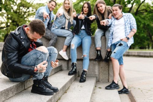 group of young people mocking their friend