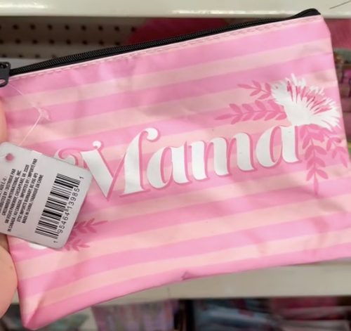 A shopper holds a pink cosmetic bag with the word "mama" on it while looking for the best Mother's Day gifts at Dollar tree.