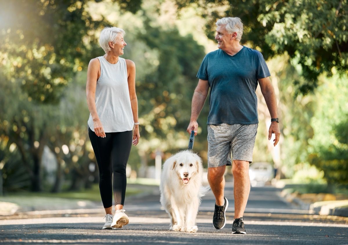 older couple walking dog