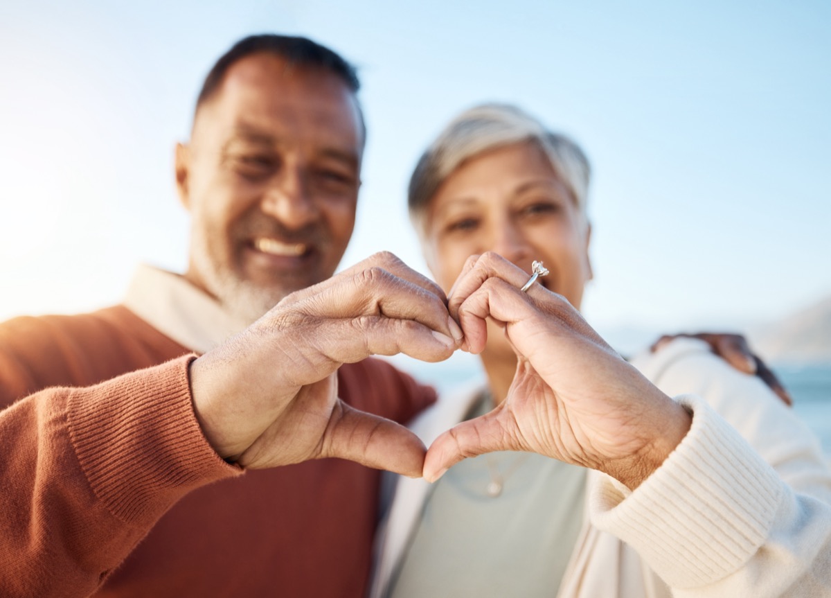senior couple making a heart with their hands