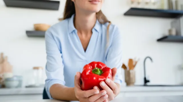 woman holding red bell pepper