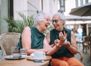 two mature twin women having coffee together outside