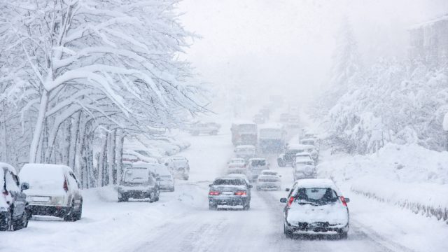 A rural roadway during a snowstorm