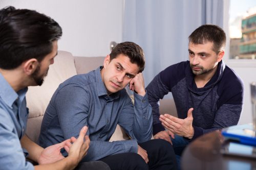 Three men or brothers arguing on a couch