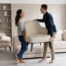 couple moving chairs into their new home