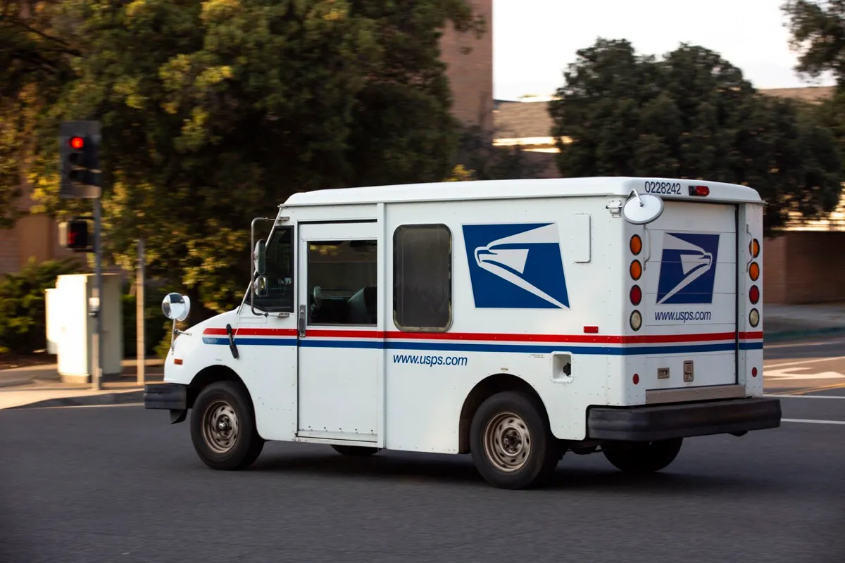 A USPS (United States Parcel Service) mail truck leaves for a delivery.