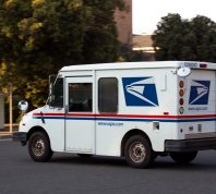 A USPS (United States Parcel Service) mail truck leaves for a delivery.
