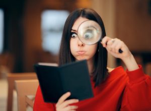 Woman in a red sweater looking at a restaurant bill with a magnifying glass