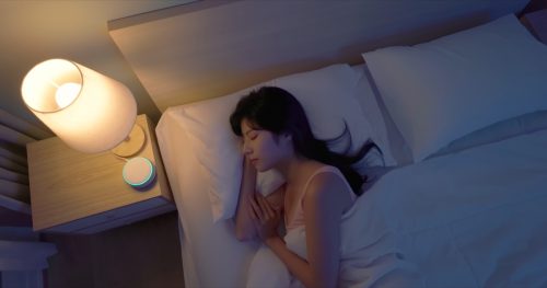 woman sleeping next to a sound machine