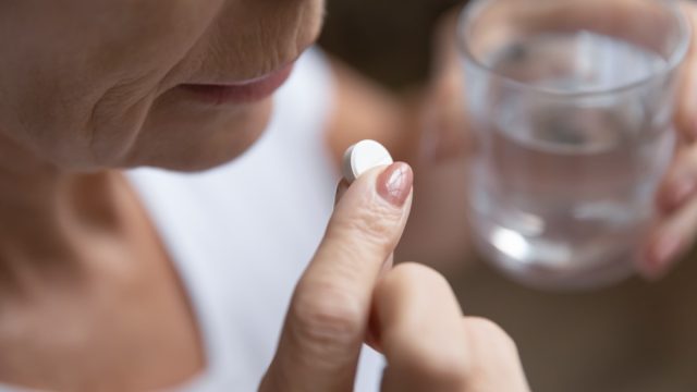 Close up of senior woman taking a supplement