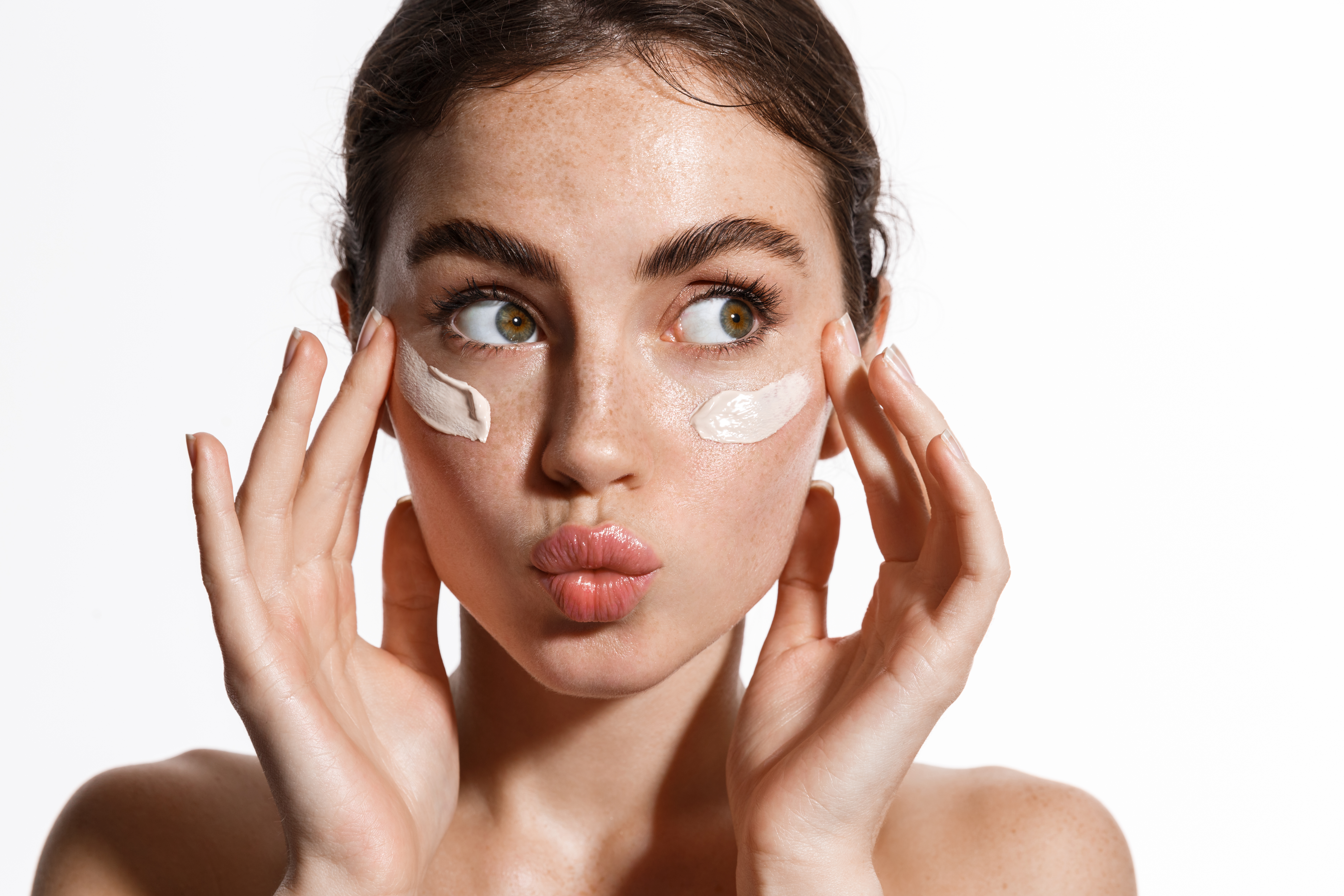 Closeup of young woman putting on sunscreen