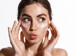 Closeup of young woman putting on sunscreen