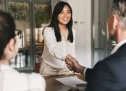 Woman smiling and shaking hands at job interview