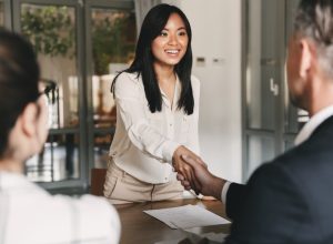 Woman smiling and shaking hands at job interview