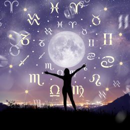 Astrological zodiac signs inside of horoscope circle surrounding the moon in a night sky