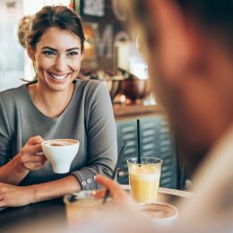 Adorable young couple drinking coffee together in city cafe.