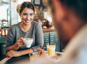 Adorable young couple drinking coffee together in city cafe.