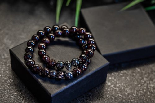 Set of luxury jewelry, black handmade bracelets made of natural stones and minerals. On black