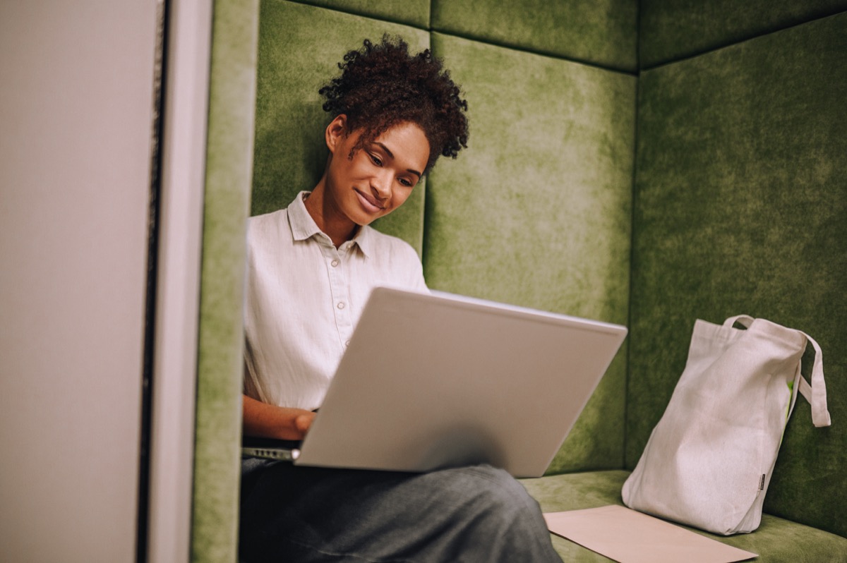 Concentrated young woman working on her portable computer