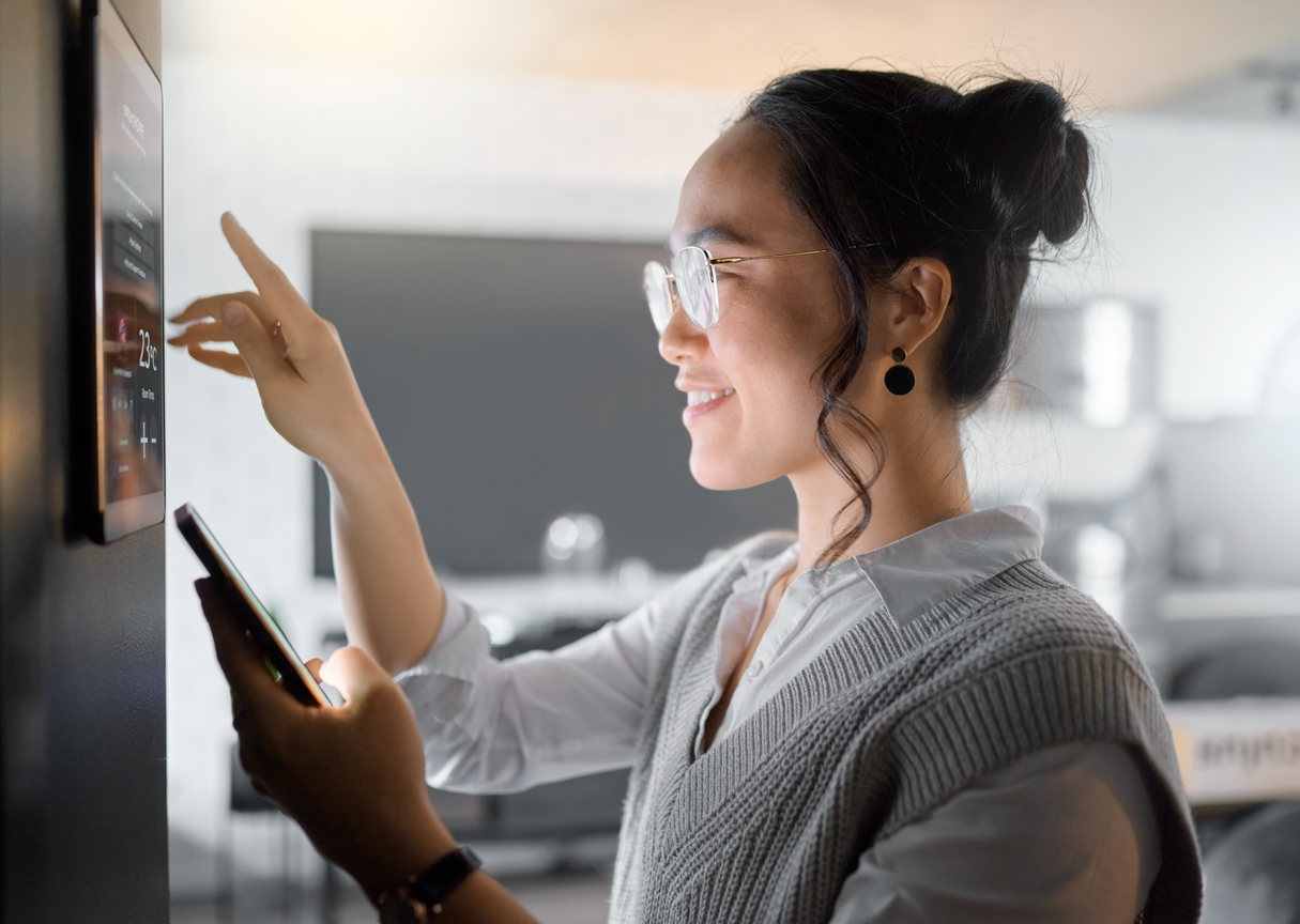 A woman using a tablet to control smart home devices