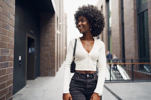 Portrait of attractive young woman walking outside in the city