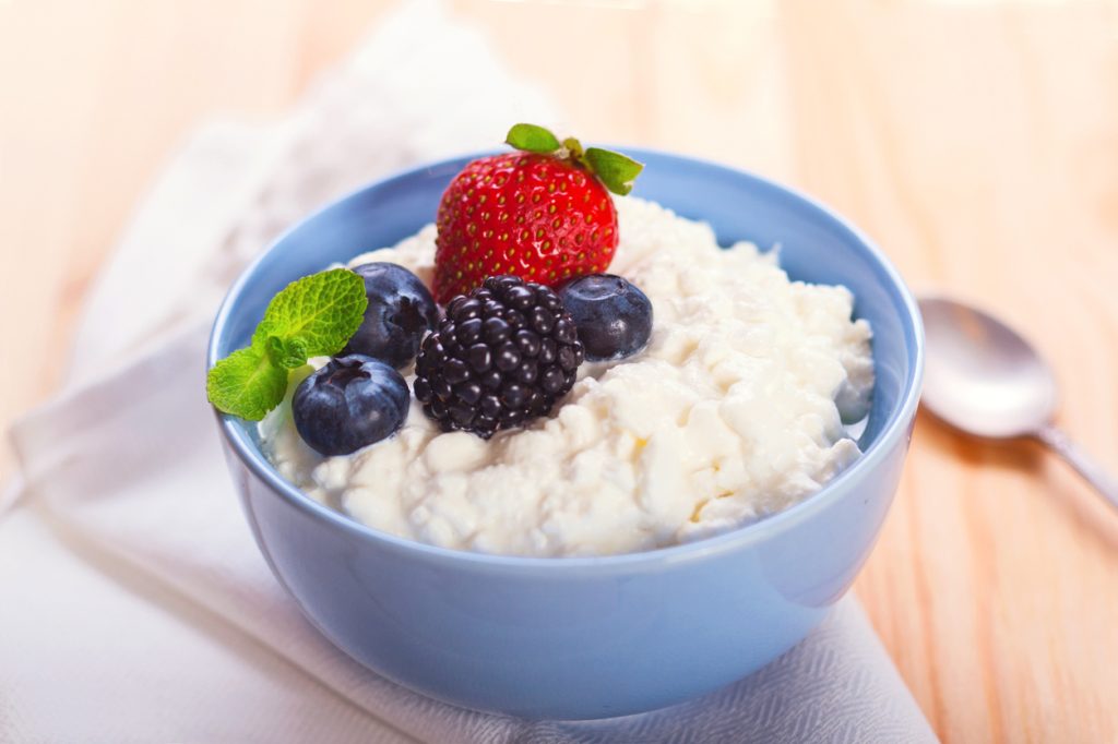 A bowl of cottage cheese with mixed berries on top