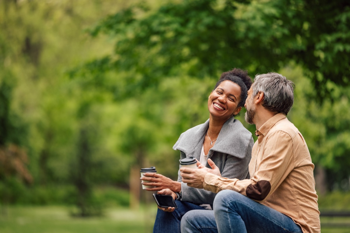 Relaxed adult couple, chatting, while enjoying their coffee.