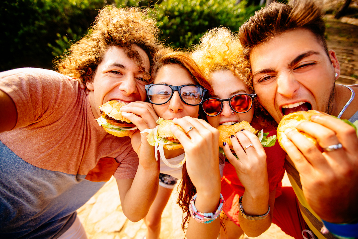 group of friends taking selfies with their hamburgers