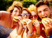 group of friends taking selfies with their hamburgers