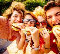 group of friends taking selfies with their hamburgers