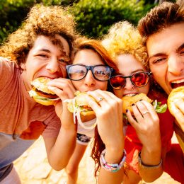 group of friends taking selfies with their hamburgers