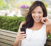 woman smiling while reading good afternoon greetings from her phone