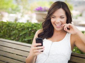 woman smiling while reading good afternoon greetings from her phone