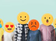 People standing in a row with their faces covered by emojis