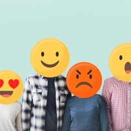 People standing in a row with their faces covered by emojis