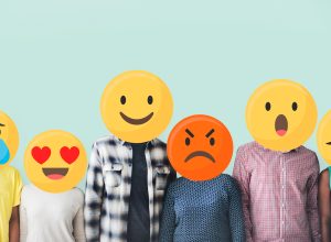 People standing in a row with their faces covered by emojis