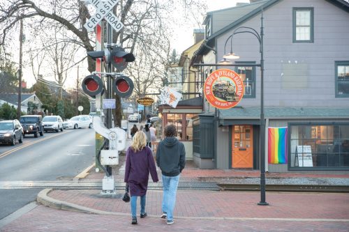 couple walking in new hope, pa past a store with a pride flag