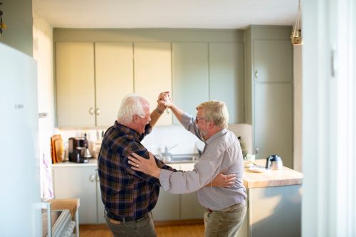 older male couple dancing in the kitchen
