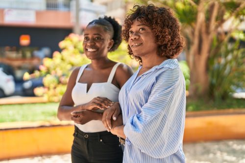 mother and daughter standing together at park