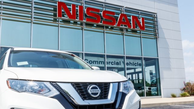 White Nissan car oustide a dealership